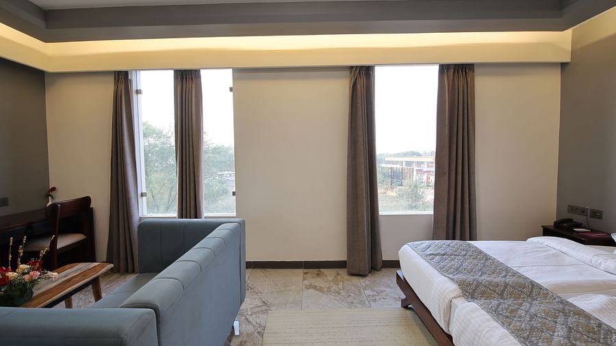 Deluxe King Room with twin beds, large windows and soft lighting at Clarks Inn Suites Jaipur, Ajmer Road